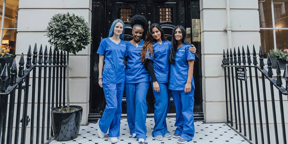 XERF radiofrequency skin tightening London - four nurses outside a Georgian clinic entrance Four nurses in blue scrubs outside a Georgian clinic entrance, XERF radiofrequency skin tightening London